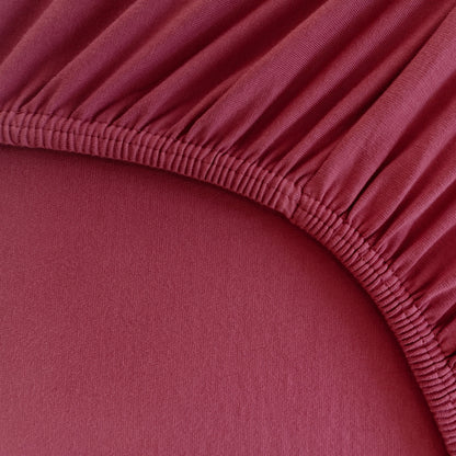 Detailaufnahme eines Spannbettlakens für Boxspringbetten und Wasserbetten mit Rundumgummi in Rot