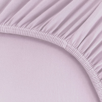 Detailaufnahme von einem Spannbetttuch für Boxspringbetten und hohe Matratzen mit starkem Rundumgummi in Hellviolett