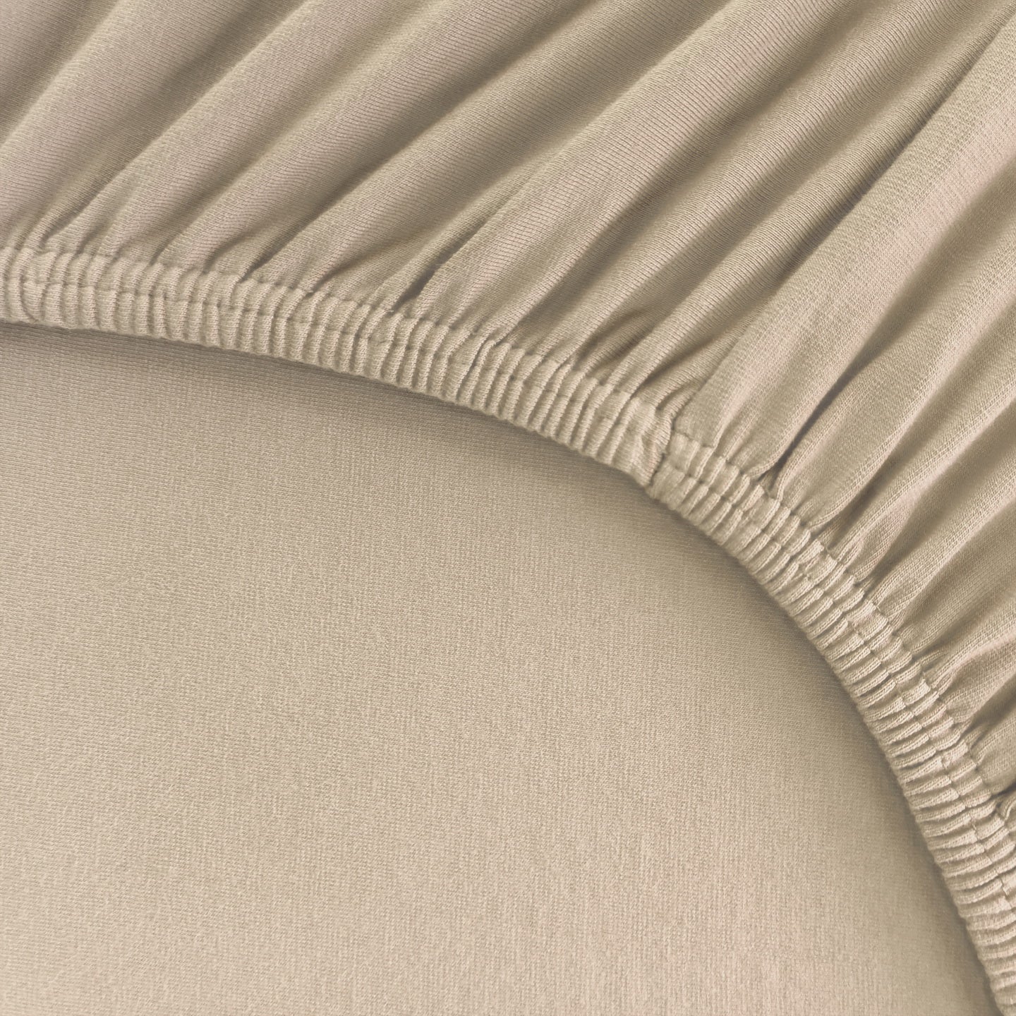 Detailaufnahme eines Spannbettlakens für Boxspringbetten und hohe Matratzen mit Rundumgummi in Sand